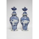 A pair of 18th century Dutch monochrome delft baluster vases & covers painted with water flow; "
