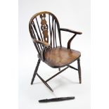 A wheel-back carver chair with hard seat & on turned legs with spindle stretchers. (Front leg