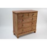 A pine chest fitted two short and three long graduated drawers with turned knob handles, and bun