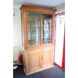 A VICTORIAN- STYLE TALL PINE CABINET fitted three shelves enclosed by part of glazed doors above