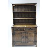 A small oak dresser fitted two open shelves to the panelled back, and the base fitted two frieze