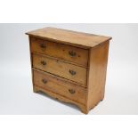 An early 20th century pine small chest fitted three long graduated drawers with brass swing handles,