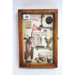 A small wall cabinet, the glazed door decorated with numerous golf-related items, 7¾” wide x 11¾”