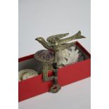 A brass sewing clamp/pin cushion with bird surmount, 5” high; a Beehive needle gauge; a Bell