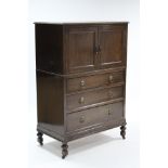 A mid-20th century oak tallboy enclosed by pair of panel doors above three long graduated drawers