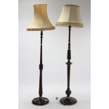 Two beech standard lamps, each with carved & turned centre column & circular base, with shades.