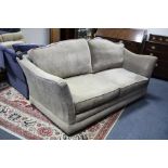 A modern three-seater settee with shaped back & sides & with loose cushions upholstered mushroom