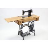 Another Singer treadle sewing machine in oak case & on iron base, 34” wide.