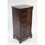 A reproduction mahogany serpentine front upright chest fitted six long drawers, & on bracket feet,