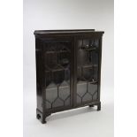 A mahogany standing bookcase with three adjustable shelves enclosed by pair of glazed doors, & on