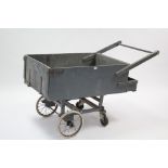 A grey painted wooden hand cart with 11” diam. spoke wheels, 51½” long.