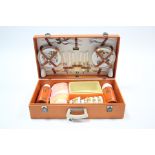 A Brexton orange fibre-covered picnic case with contents.