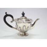 An Edwardian round semi-fluted teapot with waved rim, on low pedestal foot; Sheffield 1903, by