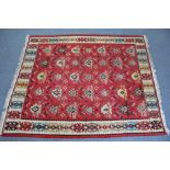 A Kelim rug of crimson ground with all-over multi-coloured geometric motifs; 8’ 2” x 6’ 8”.