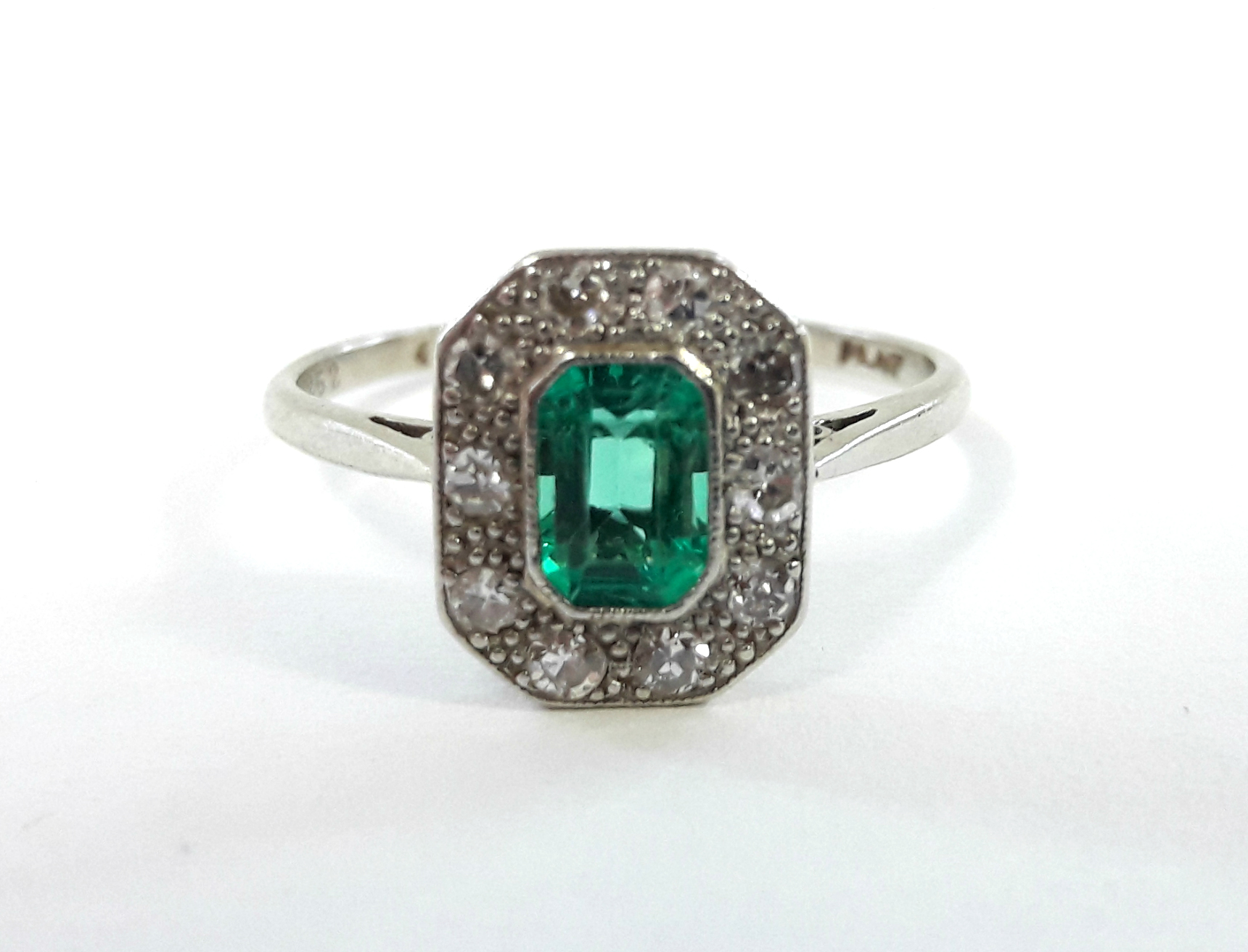 A platinum ring set rectangular emerald within a border of ten small diamonds. - Bild 2 aus 3