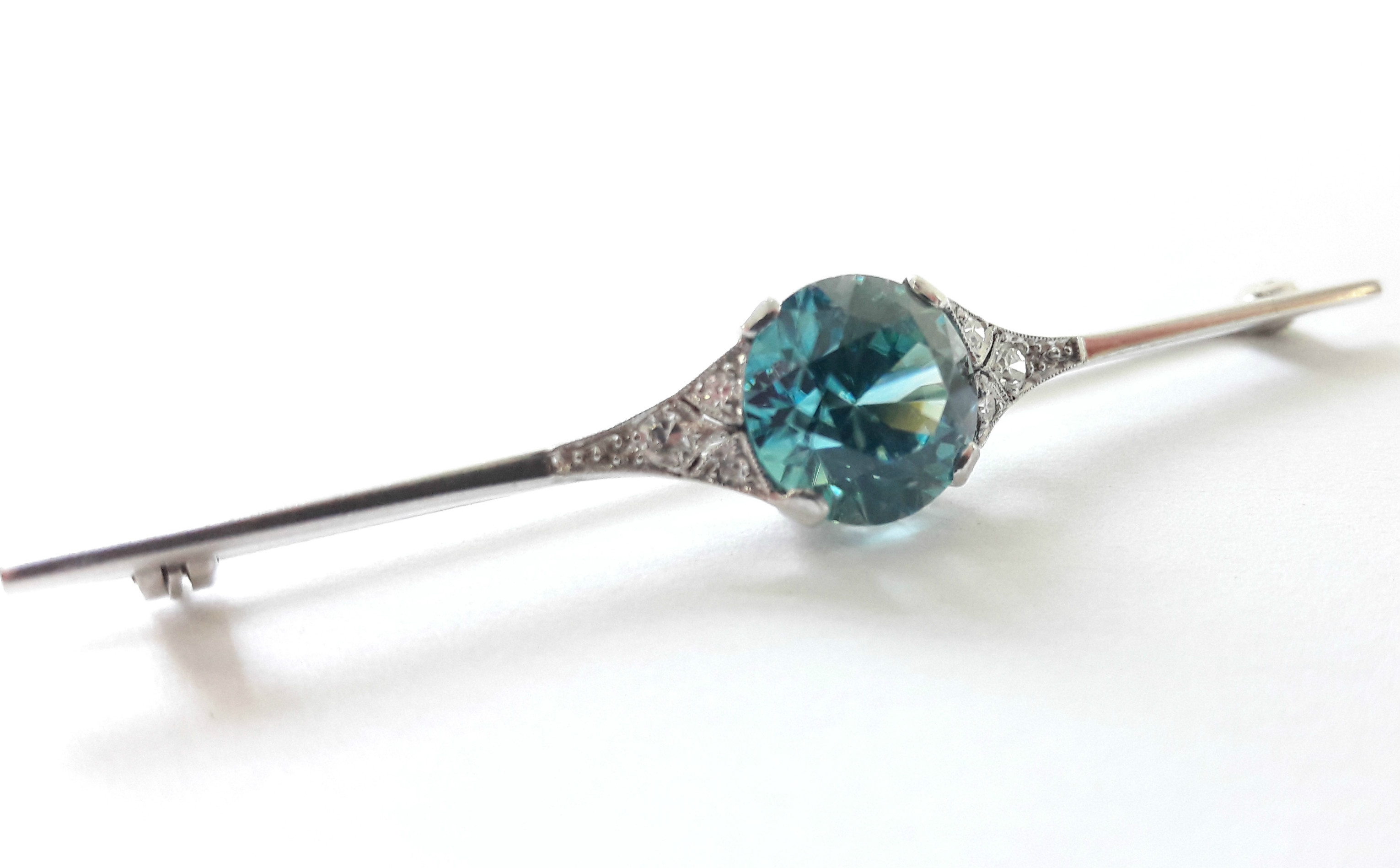 An Art Deco white metal knife-edge bar brooch set large blue zircon of approx. 4 carats, a trio of