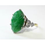 AN 18ct. GOLD, JADE & DIAMOND RING, the pierced oval jade panel carved with a bird amongst