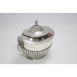 A late Victorian tea caddy of oval semi-fluted form, with domed hinged lid, lion-mask & ring side