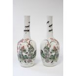 A pair of Chinese porcelain slender ovoid vases with tall narrow necks, each painted in famille