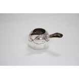A continental small brandy saucepan of rounded form with lobed shoulder, the short carved wood