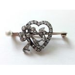 An Edwardian gold open-work heart & ribbon-bow brooch set forty two small diamonds, & a pearl to one