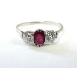 A ruby & diamond ring, the oval centre stone with a diamond either side, each of approx. 0.25 carat,