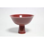 A CHINESE PORCELAIN SANG-DE-BOEUF GLAZED STEM BOWL with slightly flared rim, & on slightly tapered