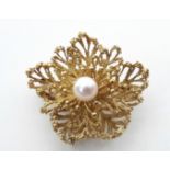 An 18ct. gold open-work flower-head design brooch set single pearl to centre (15-6gm gross).