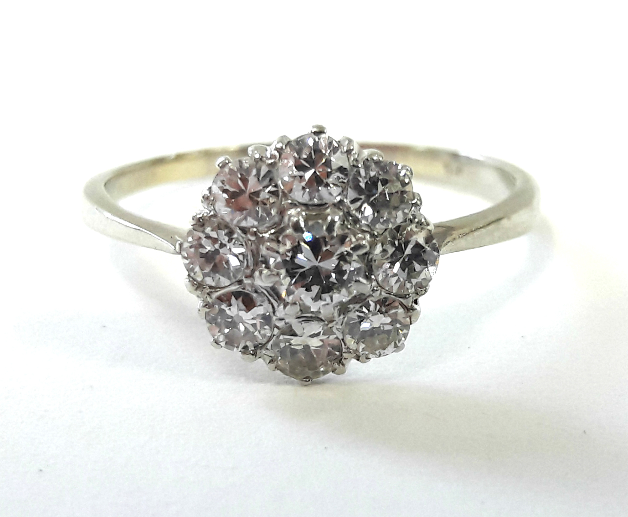 A platinum ring set cluster of nine diamonds, the centre stone approx. 0.2 carat.