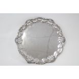 An Edwardian small salver with raised “Chippendale” border, on three claw-&-ball feet, 10½” diam.;