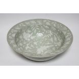 A Chinese porcelain celadon ground deep bowl, the interior all-over painted with scattered flowers