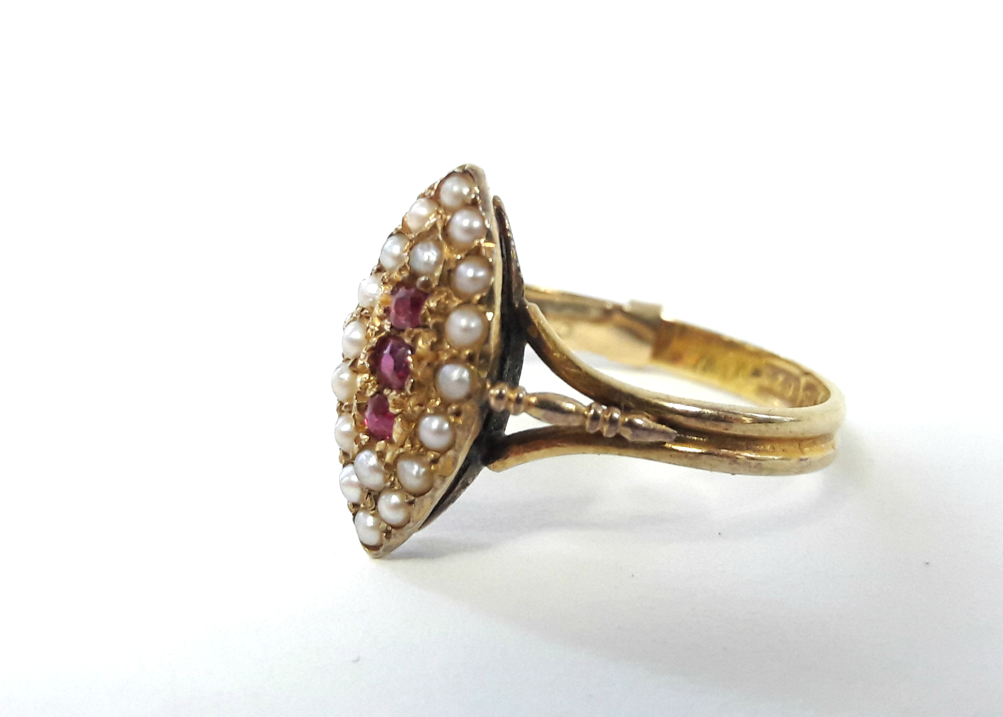 A 15ct. gold ring with navette shaped panel set three small rubies surrounded by seed pearls. - Bild 3 aus 4