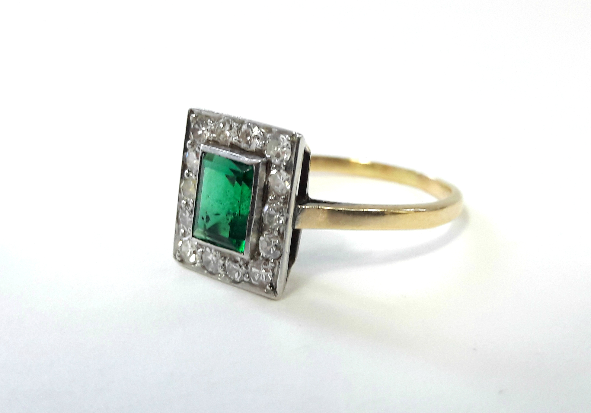 AN EMERALD & DIAMOND RING, the centre rectangular emerald set within a border of fourteen small - Bild 2 aus 3