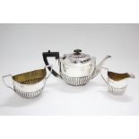 A late Victorian three-piece tea service of oval semi-fluted design; Chester 1896, by Florence