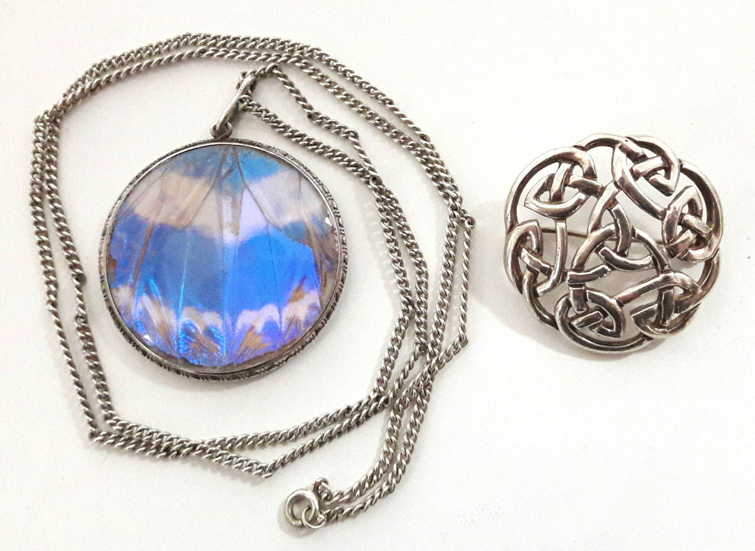 A sterling pierced circular Celtic knot brooch, 1¼” diam.; & a circular pendant inset butterfly