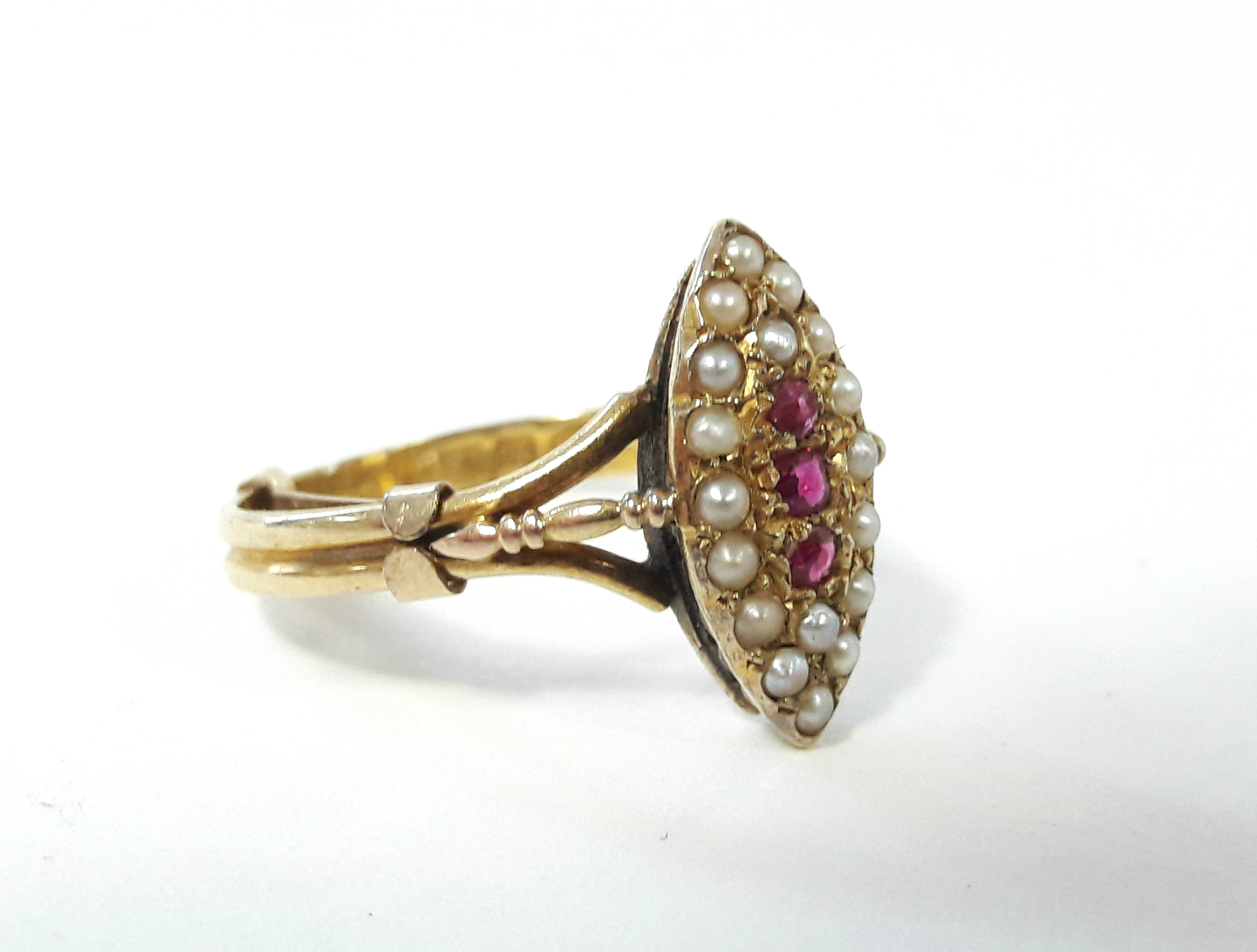 A 15ct. gold ring with navette shaped panel set three small rubies surrounded by seed pearls. - Bild 2 aus 4