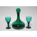 A 19th century emerald glass squat round decanter with tall narrow neck & round flat-sided stopper