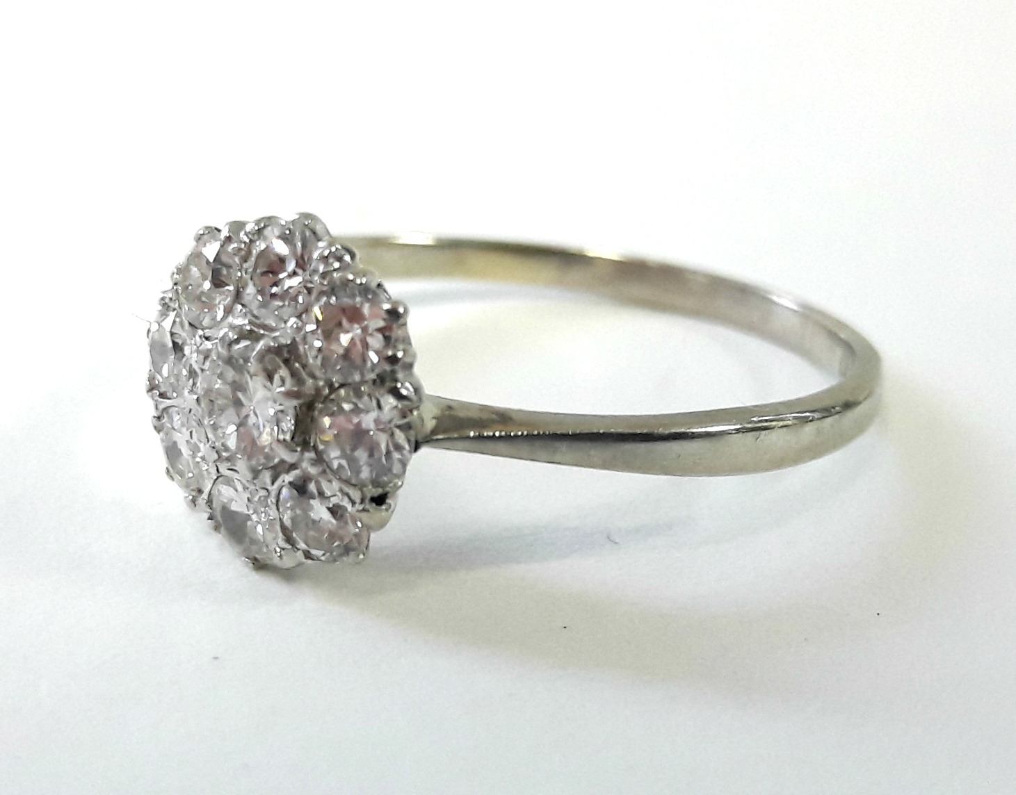 A platinum ring set cluster of nine diamonds, the centre stone approx. 0.2 carat. - Bild 2 aus 3