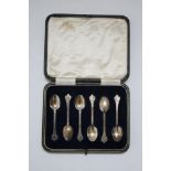 A set of six coffee spoons with scroll-decorated trefid terminals; Sheffield 1930, b Thos.