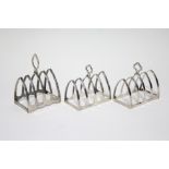 A pair of lancet-shaped four division toast racks, Sheffield 1937, by Brook & Sons; & another,