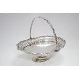 An Edwardian oval cake basket with swing handle, cast scroll rim & pierced border, on oval