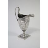 A George III helmet-shaped milk jug with engraved floral decoration & monogram, reeded loop handle &