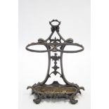 A Victorian cast iron two-division umbrella stand of scroll design; 20” wide x 28” high.