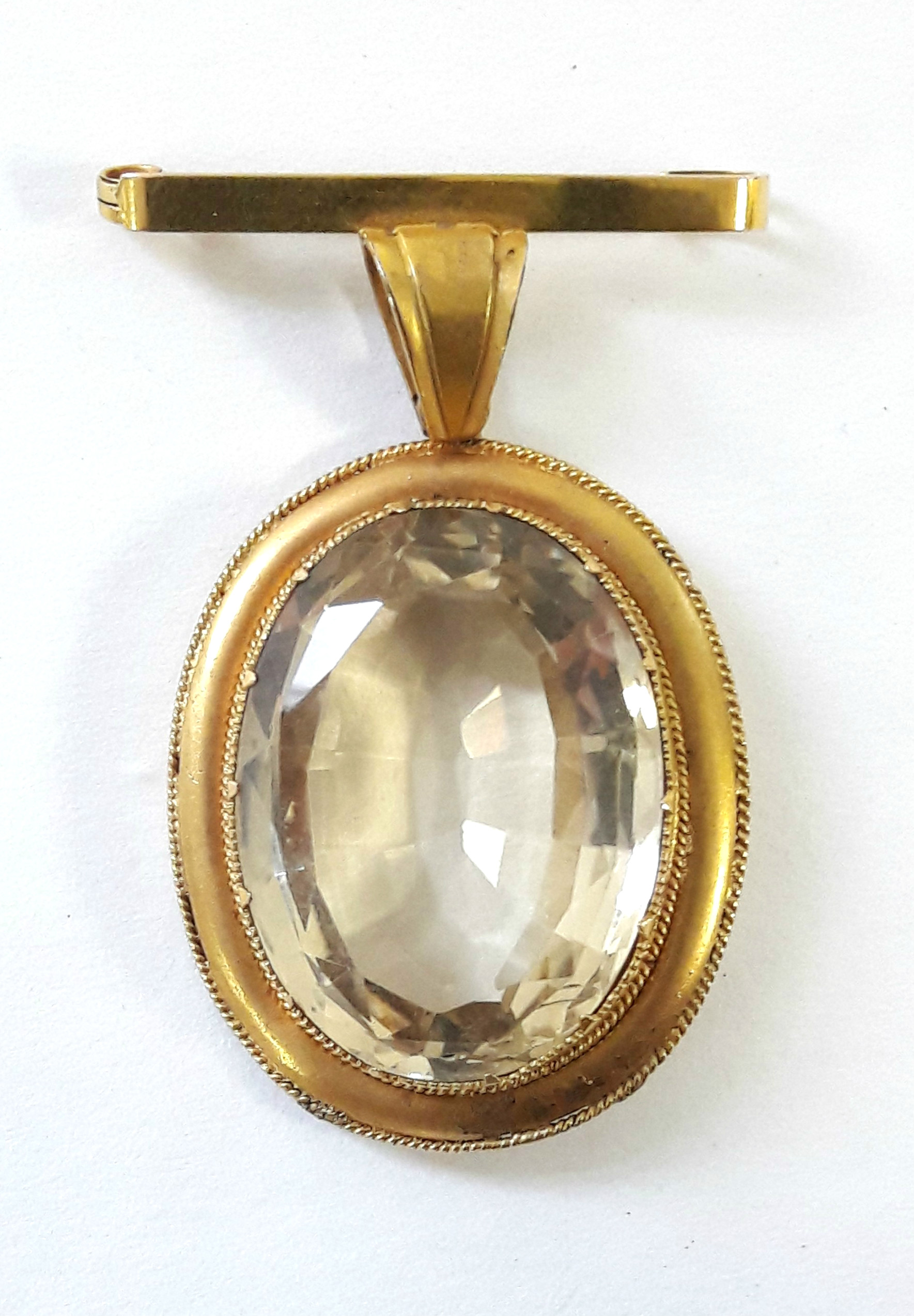 A large oval citrine pendant in 9ct. gold mount with integral bar brooch; Chester 1921.