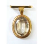 A large oval citrine pendant in 9ct. gold mount with integral bar brooch; Chester 1921.