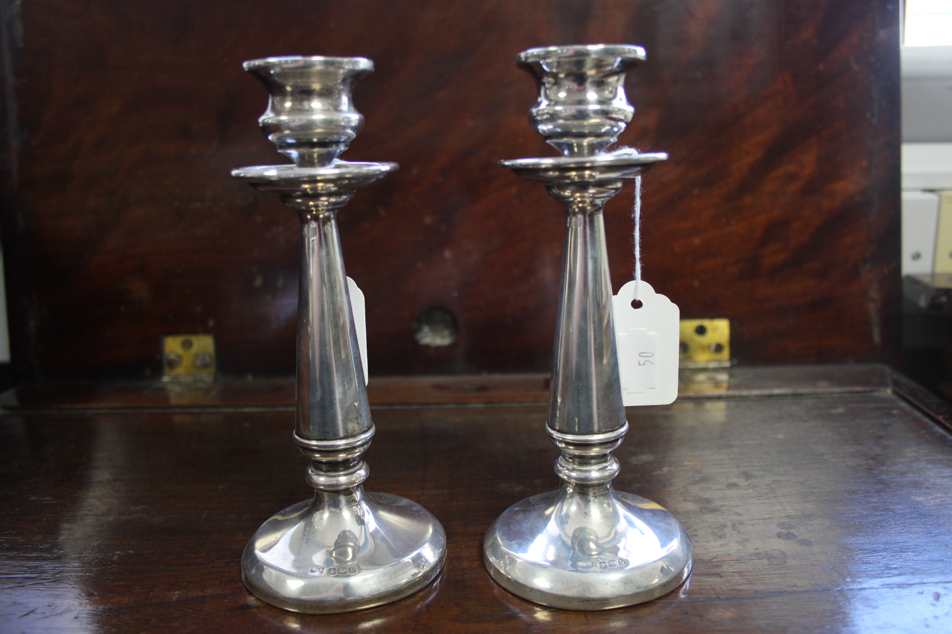 A pair of 6¾” candlesticks with wide drip-pans above the round tapered columns, on circular bases;
