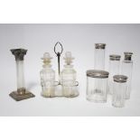 Five cut glass toilet case bottles with engine-turned silver lids; a condiment stand with centre