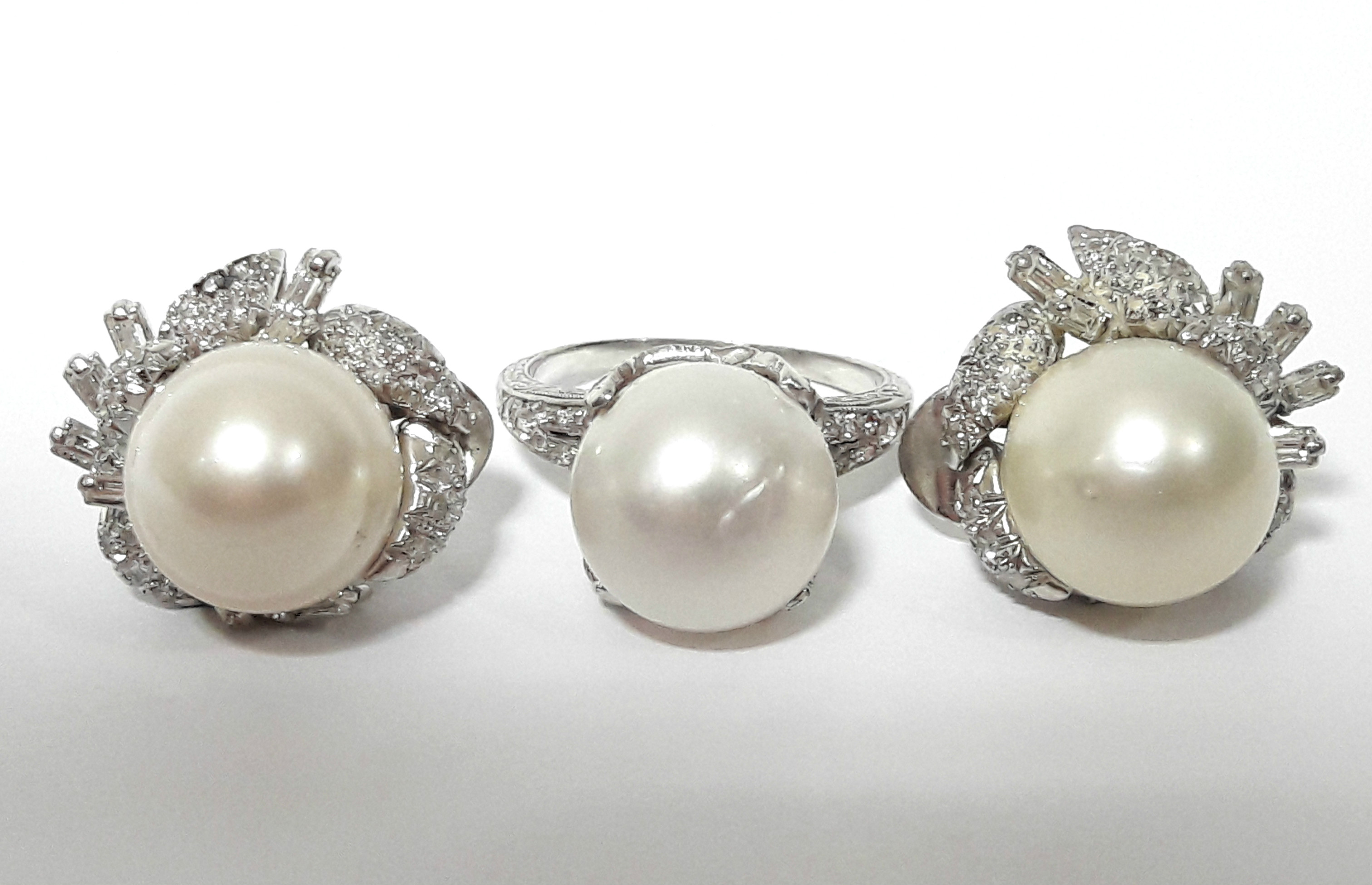 A pair of 14K white gold earrings, each set large pearl & numerous small round & baguette