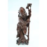 A Chinese carved hardwood standing figure of a sage holding a peach & long staff; 16½" high.