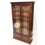 A 19th century mahogany tall bookcase with four adjustable shelves enclosed by pair of glazed